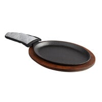 Valor 9 1/4" x 7" Oval Pre-Seasoned Cast Iron Fajita Skillet with Rustic Chestnut Finish Rubberwood Underliner and Grey Silicone Handle Cover
