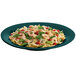 A Hunter Green and White speckled cast aluminum platter with pasta, shrimp, and vegetables.