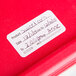 A red plastic container with a National Checking Company Dissolvable Product Label on it.