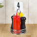 An American Metalcraft chrome condiment caddy with a number card holding a red bottle and condiments.