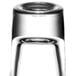 An Arcoroc tall shot glass with a black rim filled with a clear liquid.
