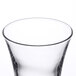 An Arcoroc shot glass with a small amount of liquid in it.