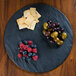 A Tablecraft Frostone melamine display tray with fruit and crackers on a wood table.