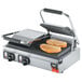 A Vollrath double panini sandwich grill with two sandwiches on it.
