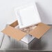 A white styrofoam box with a lid open containing food.
