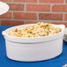 A Tablecraft white shell casserole dish filled with pasta on a table.