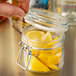A person holding a Libbey Garden Jar filled with lemon slices.