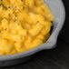 A Tablecraft granite cast aluminum fry pan filled with macaroni and cheese.