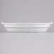 A white Tablecraft cast aluminum oval casserole dish with handles.