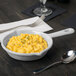 A Tablecraft natural cast aluminum fry pan filled with macaroni and cheese on a table.