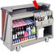 A cart with bottles of alcohol and drinks with a Cambro ice sink cover on it.