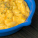 A blue Tablecraft fry pan filled with macaroni and cheese.