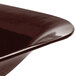 A Tablecraft Midnight Speckle brown cast aluminum square bowl with a shiny surface and curved edge.