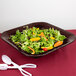 A Tablecraft Midnight Speckle black bowl filled with salad and orange peppers with spoons and forks.