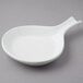 A Tuxton white china fry pan server with a handle.