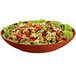 A Tablecraft copper cast aluminum pasta bowl filled with pasta and lettuce on a table in a salad bar.