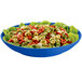 A cobalt blue Tablecraft pasta bowl filled with tortellini and lettuce.
