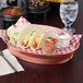 A red and white checkered table with a plate of tacos and a HS Inc. Paprika oval deli server filled with salsa.
