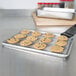 A chocolate chip cookie on a Vollrath stainless steel cooling rack.