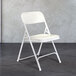 A National Public Seating white metal folding chair with white plastic seat.