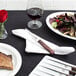 A plate of steak and a Victorinox serrated steak knife on a table.