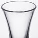 A close up of a clear plastic flared shooter/dessert shot glass.