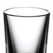 A close-up of a Thunder Group plastic shot glass with a black rim.
