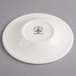 A Homer Laughlin Ameriwhite china saucer with a small design on it.