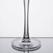 A close up of a Thunder Group clear plastic wine glass with a thin stem.