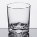 A Thunder Group clear plastic old fashioned glass with a wavy edge.