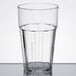 A close-up of a clear Thunder Group polycarbonate tumbler with a clear rim.