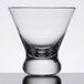 A close up of a Thunder Group clear plastic cocktail glass with a small base.