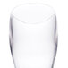 A close-up of a clear plastic Thunder Group Pilsner glass.