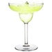 A Thunder Group plastic margarita glass filled with a green margarita, garnished with lime.