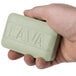 A person holding a green Lava bar of soap.