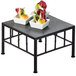 A Cal-Mil black iron square riser with slate top displaying food on a table.