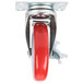 A close-up of a Winholt swivel plate caster with a red wheel and metal plate.