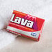 A red box of Lava bar soap on a white towel.