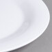 A close-up of a Carlisle white melamine plate with a narrow white rim.
