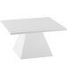 A white square pedestal riser on a white rectangular table.