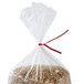 A bag of rice with red paper bag ties around it.