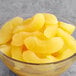 A bowl of yellow sliced apples on a table.