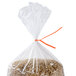 A bag of brown rice with orange paper ties on top.