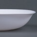 A close-up of a Fineline white plastic bowl with a white rim.