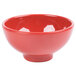 A close up of a red bowl with black specks.