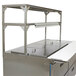 A stainless steel kitchen counter with a Delfield stainless steel double overshelf.