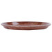 A brown Cambro round fiberglass tray with a wood grain pattern.