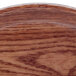 A Cambro round fiberglass tray with a Country Oak wood pattern.