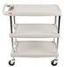 A gray Metro utility cart with three shelves and chrome posts on wheels.