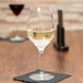 A Spiegelau Authentis white wine glass sits on a table with white wine in it.